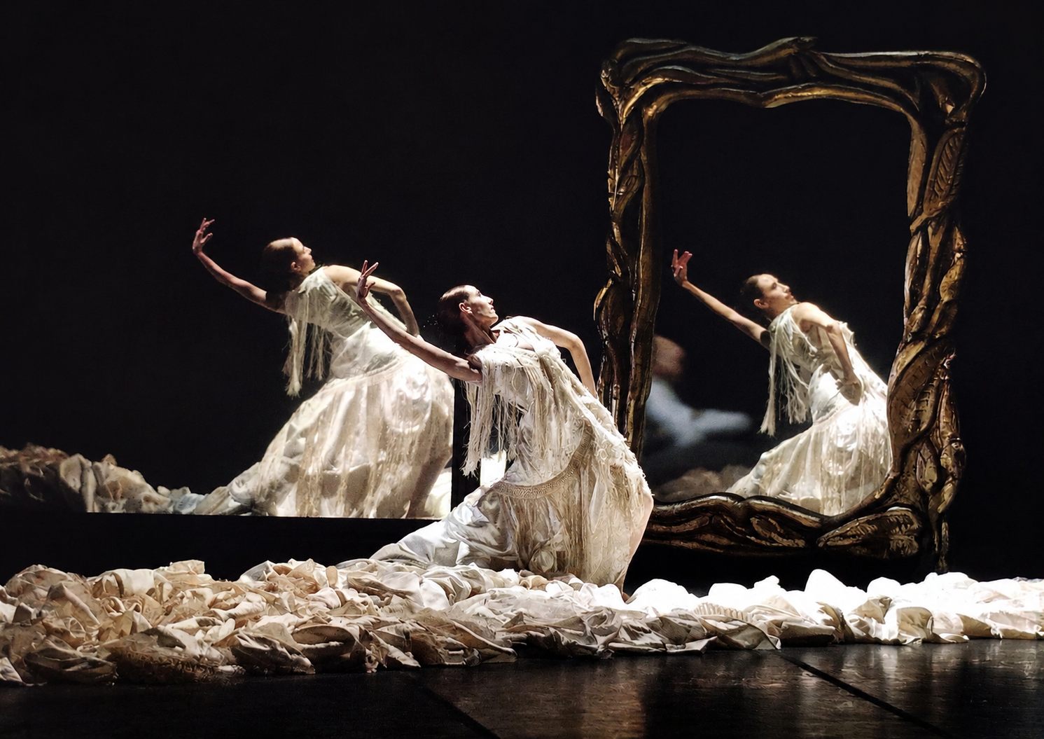 María Redelico bailando con vestido blanco junto a un espejo sobre el escenario, bailarina solista y fundadora de Developpè